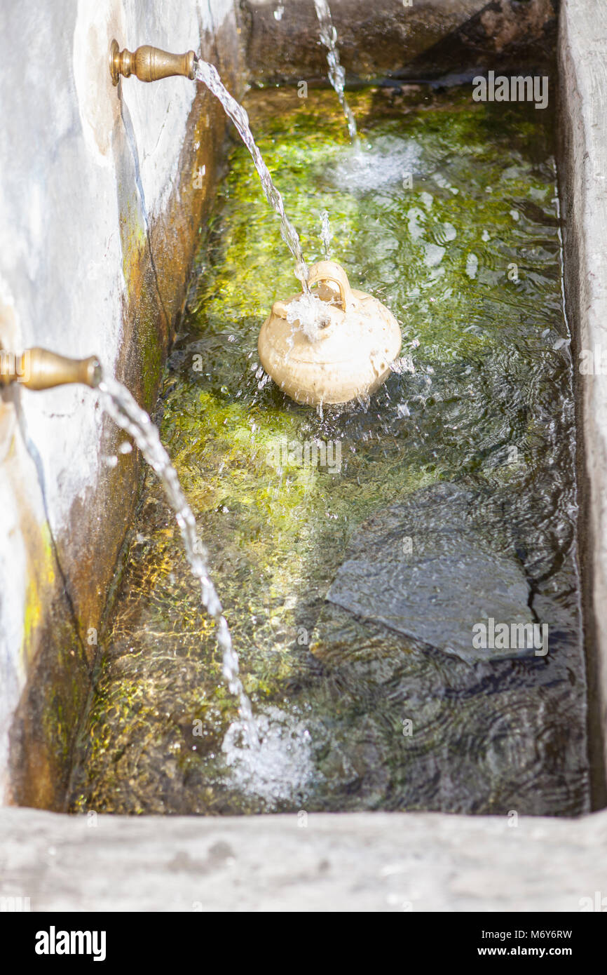 a-botijo-is-filled-with-fresh-water-at-public-fountain-of-capileira-M6Y6RW.jpg