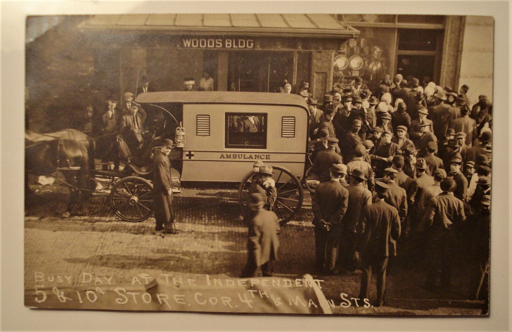 postcard indiana ambulance crowd outside store.jpg