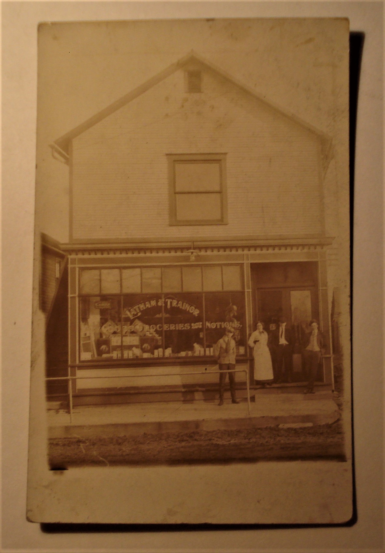 Postcard RPPC Storefront Latham & Trainor.jpg