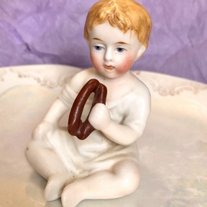 Figurine of a porcelain boy eating - front rotation