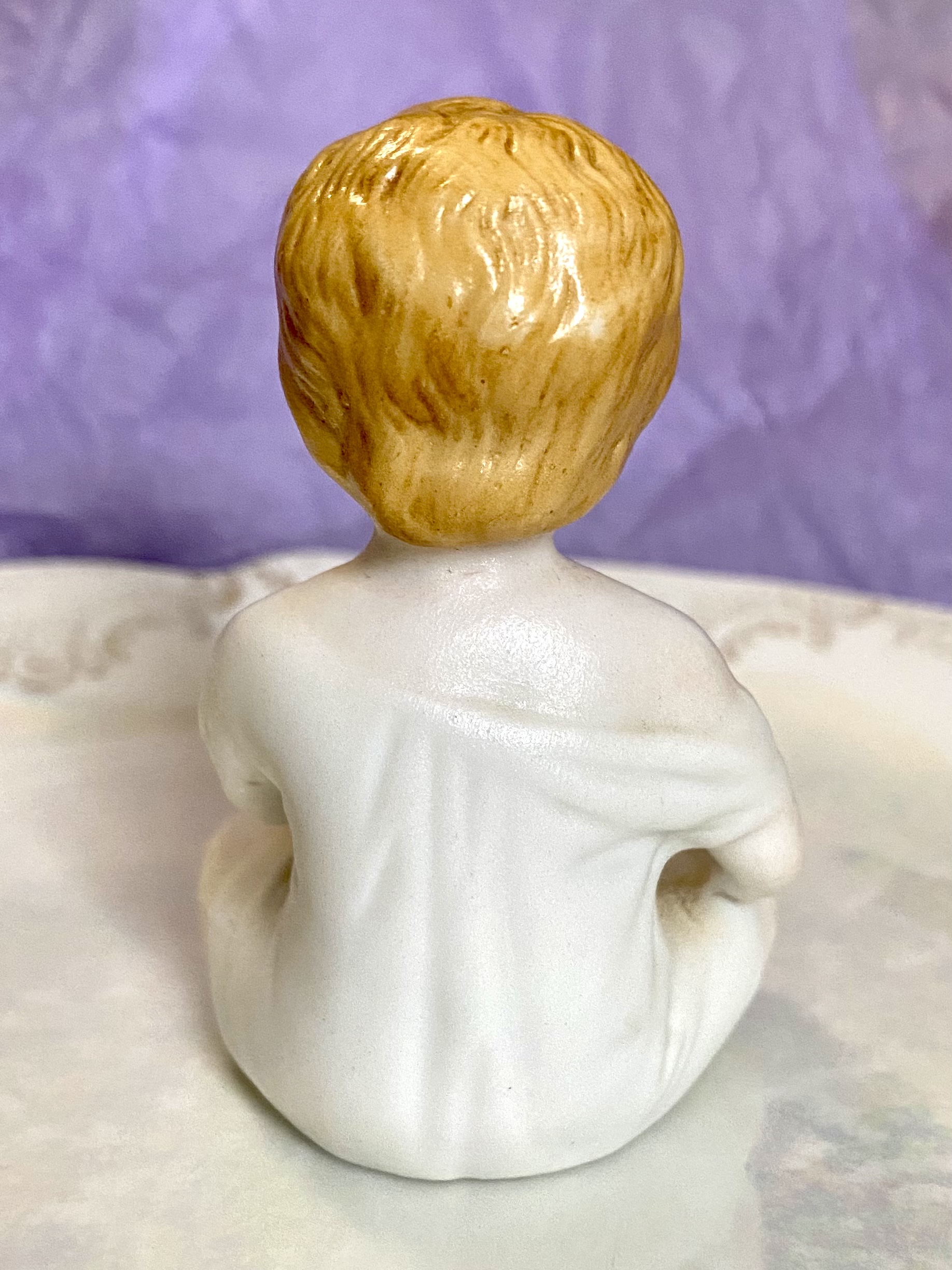 Figurine of a porcelain boy eating - back/reverse