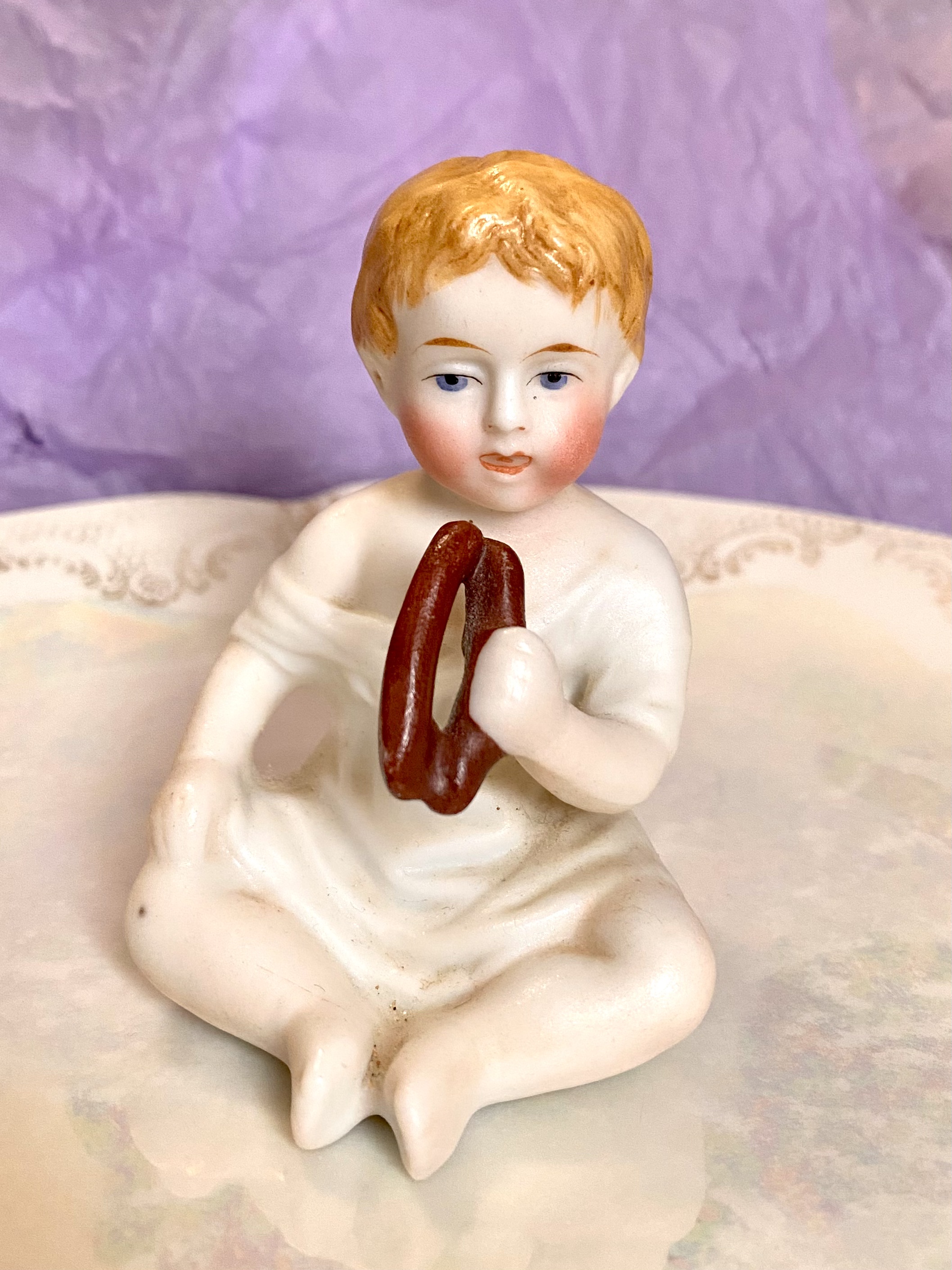 Figurine of a porcelain boy eating - front