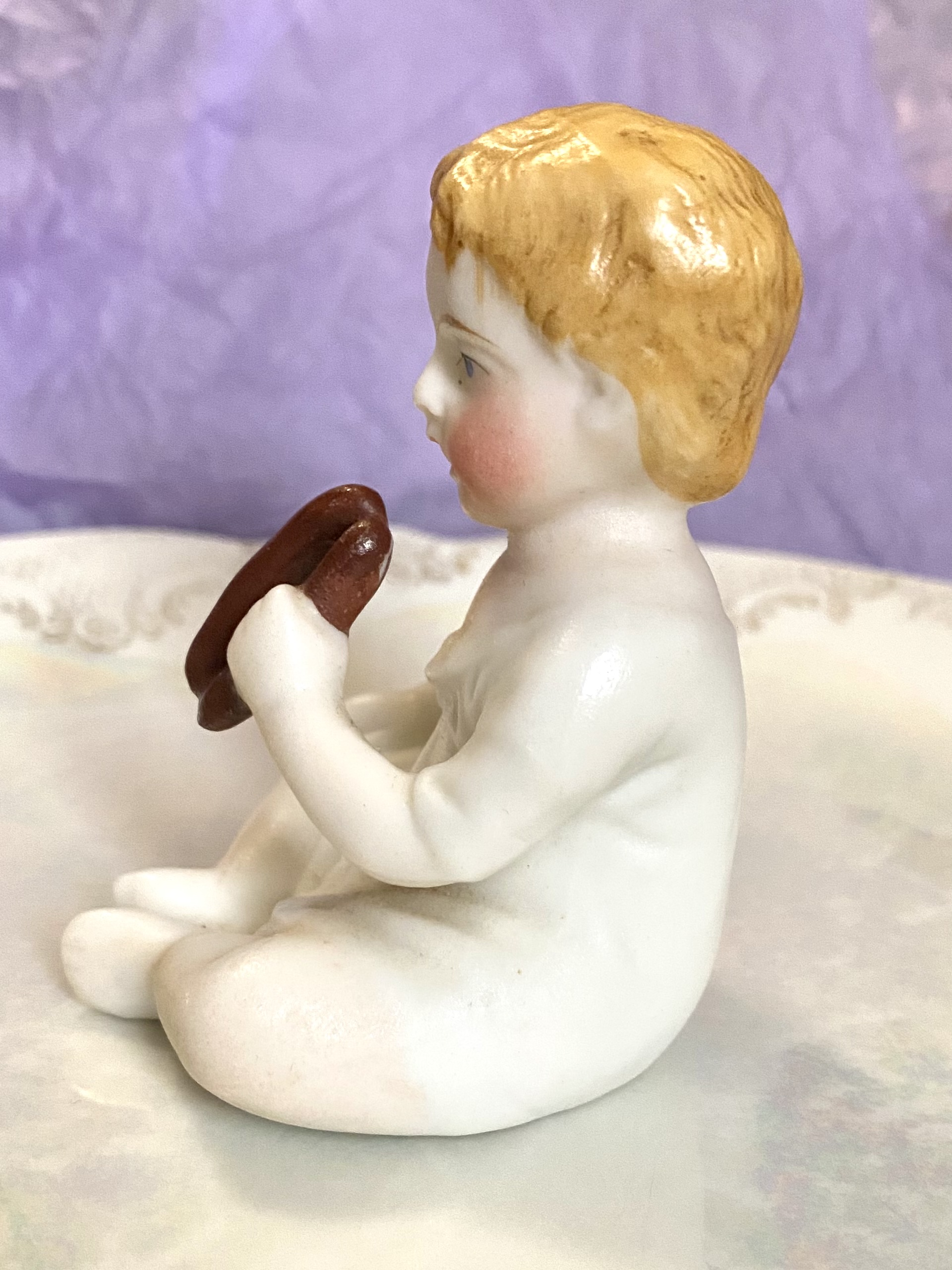 Figurine of a porcelain boy eating - left side rotation