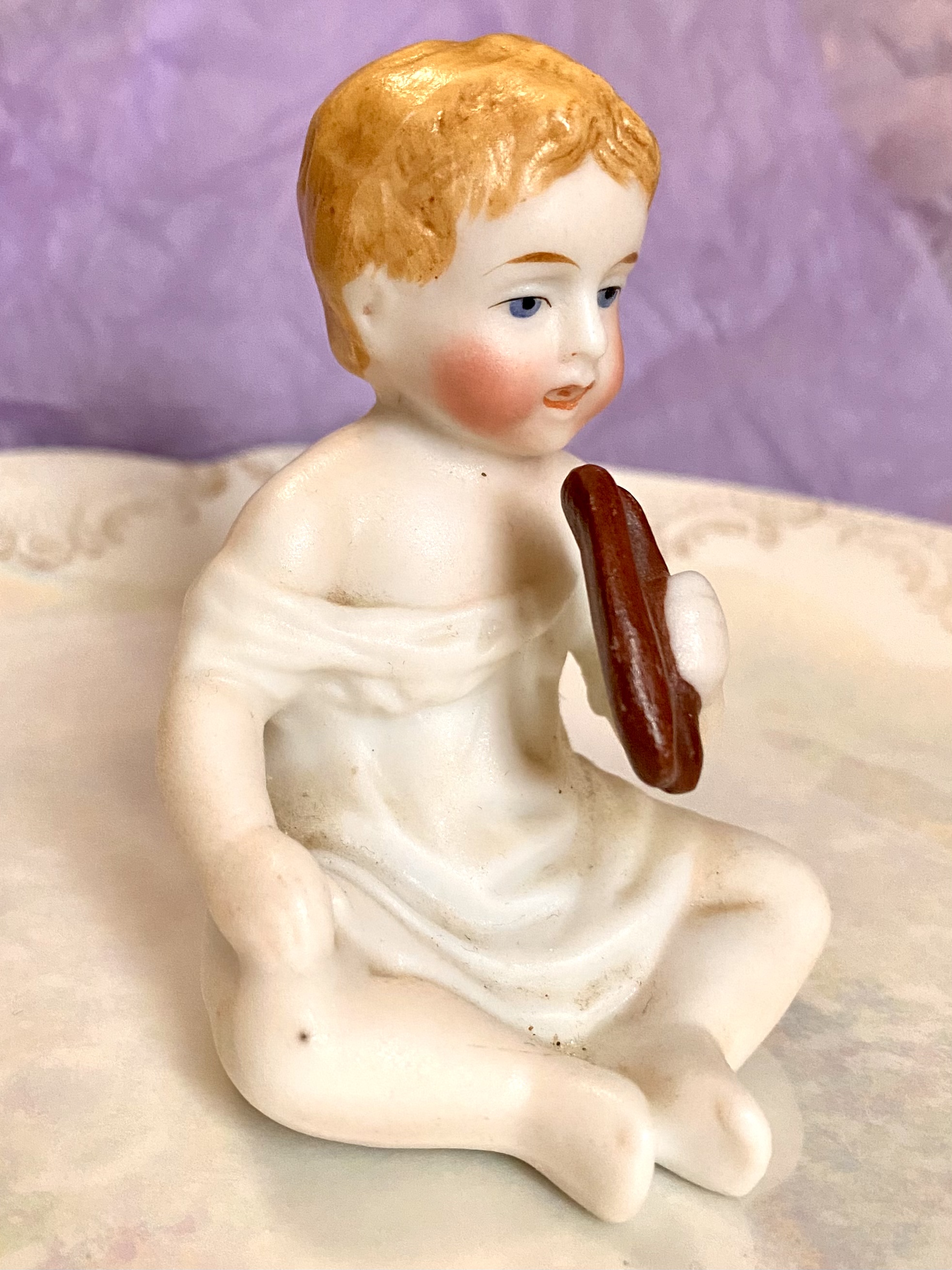 Figurine of a porcelain boy eating - right side